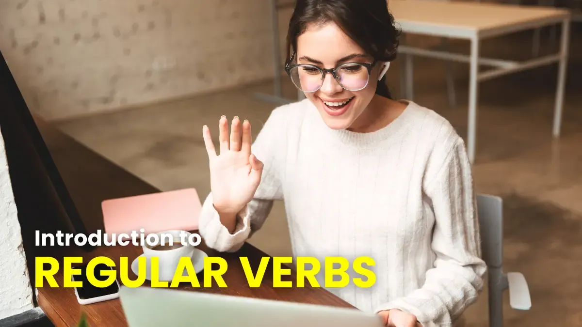 Woman with headphones waving hello while learning about regular verbs in German grammar on her computer.