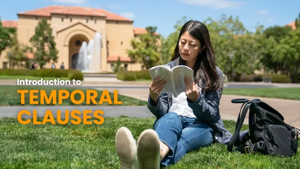 A focused student sitting on the grass, reading a book with intent concentration on a sunny campus, learning about temporal clauses in German grammar.