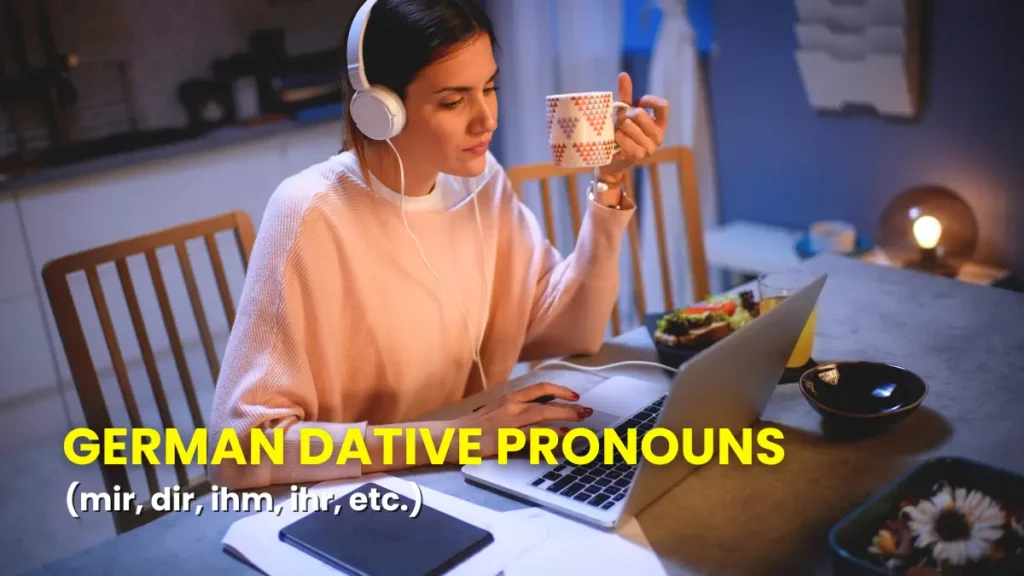 Person with headphones at a computer with a cup of coffee, learning about German dative pronouns.