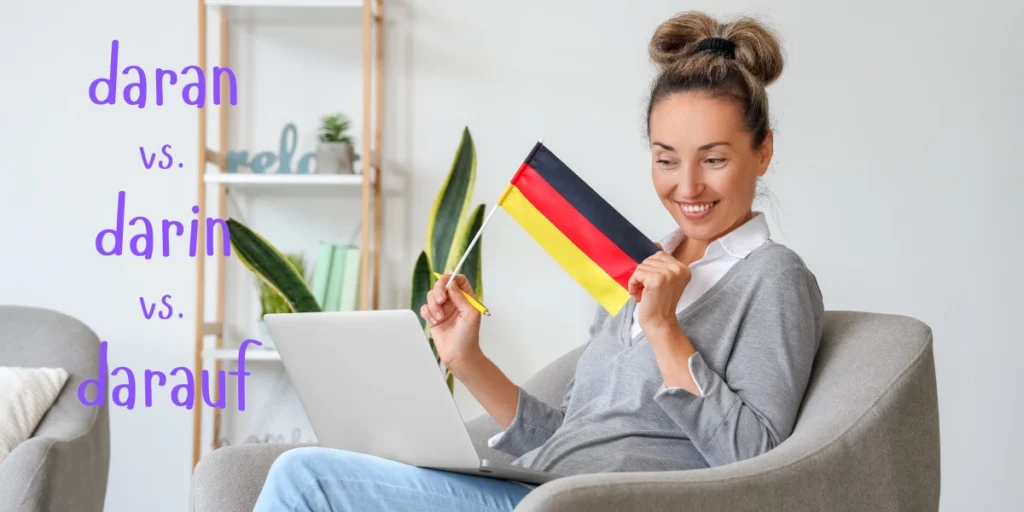 A woman holds a German flag while studying the differences between 'daran', 'darin', and 'darauf' in German grammar.